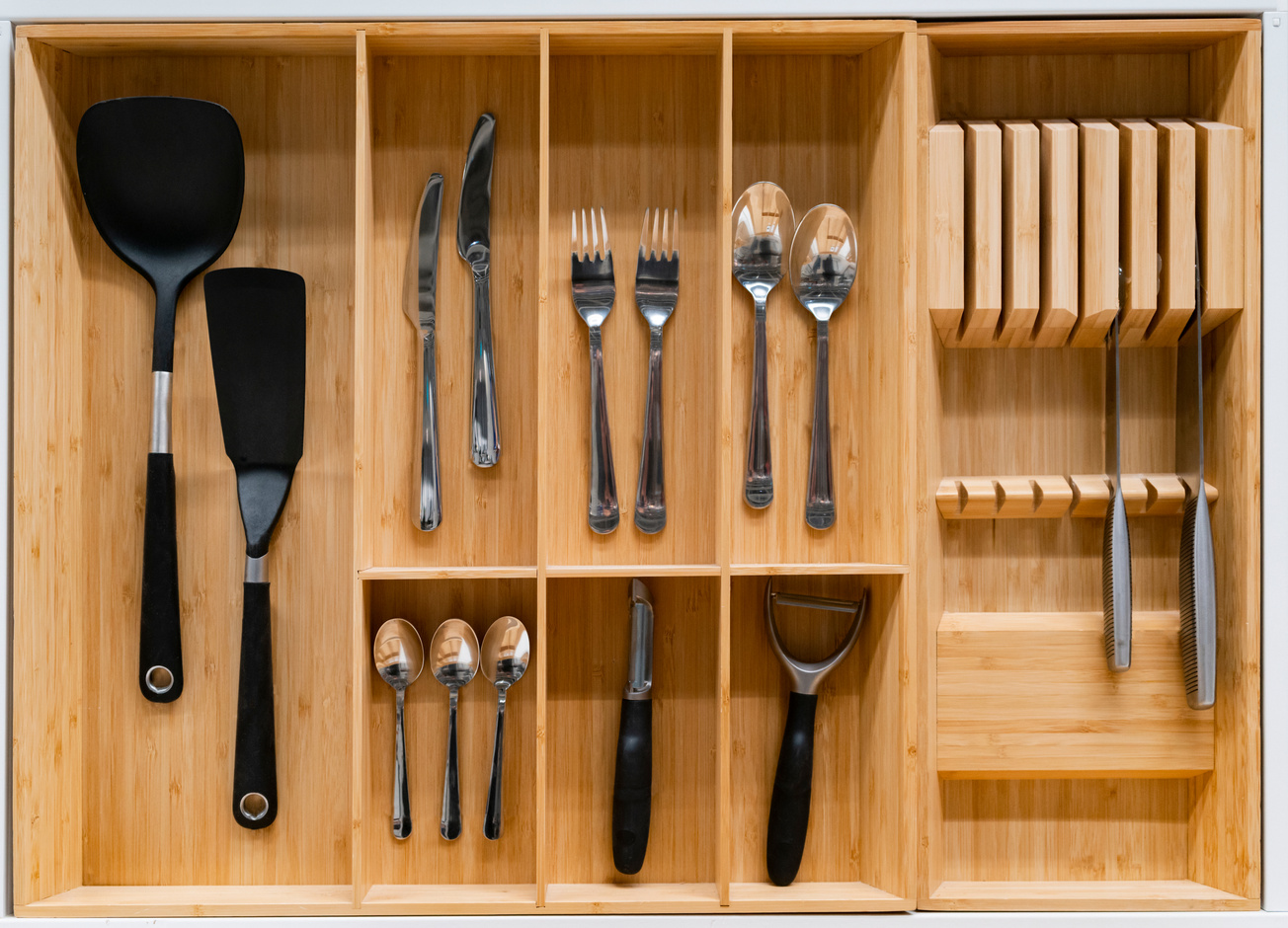 Top view of organized kitchen drawers. Modern kitchen organization of spaces.
